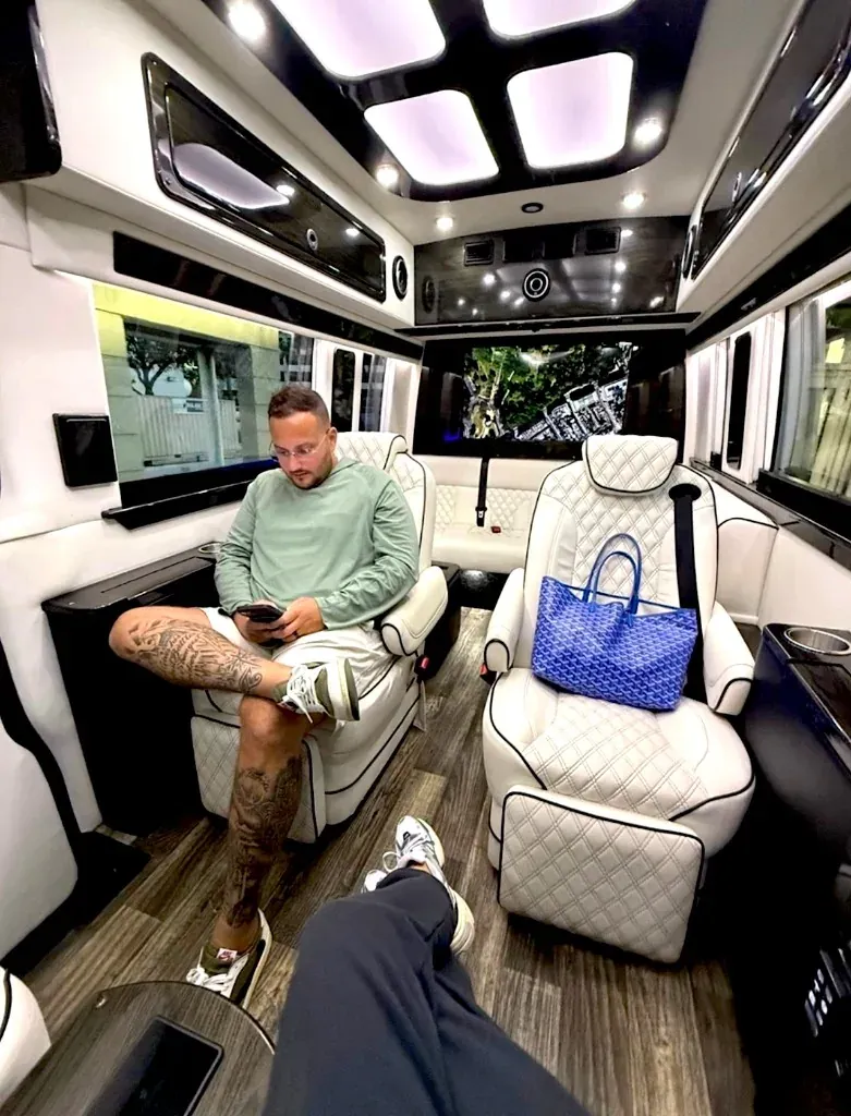 Interior of a luxury stretch limousine with champagne flutes, ambient gold lighting, and leather seating ready for guests