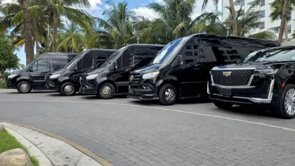 Luxurious black car interior with leather seating, bottled water, and premium cabin amenities