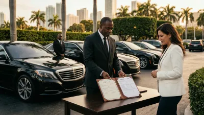 Executive sedan parked outside a glass-walled office tower in Brickell with a chauffeur reviewing a tablet