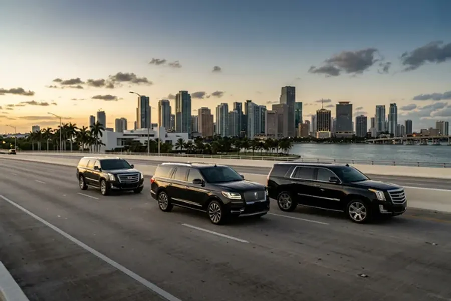 A professional stepping out of a black sedan in front of a Brickell office building, greeted by the driver