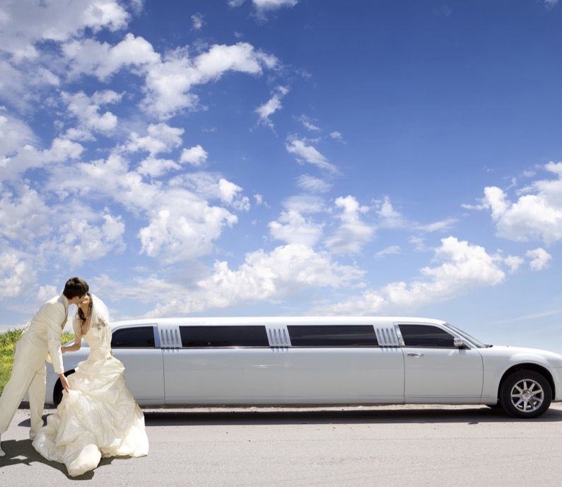 Happy bride and groom about limousine in wedding day