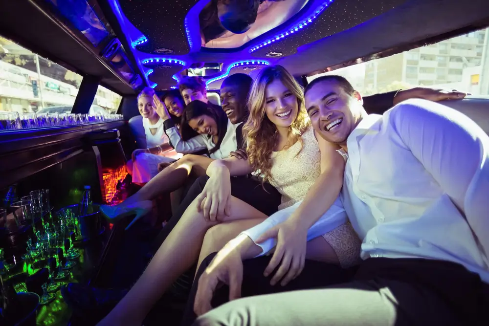 Happy friends chatting in limousine on a night out 