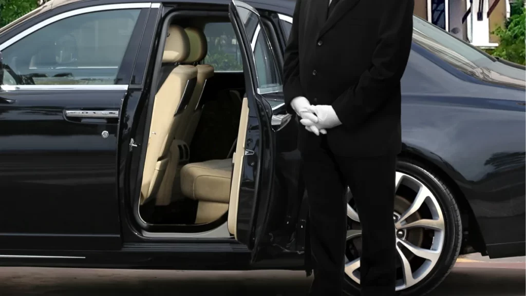 Luxury black vehicle with a suited chauffeur waiting to assist clients, representing upscale car service in Miami.
