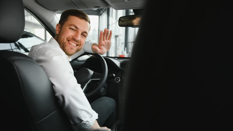 Portrait of a handsome male chauffeur sitting in a car.