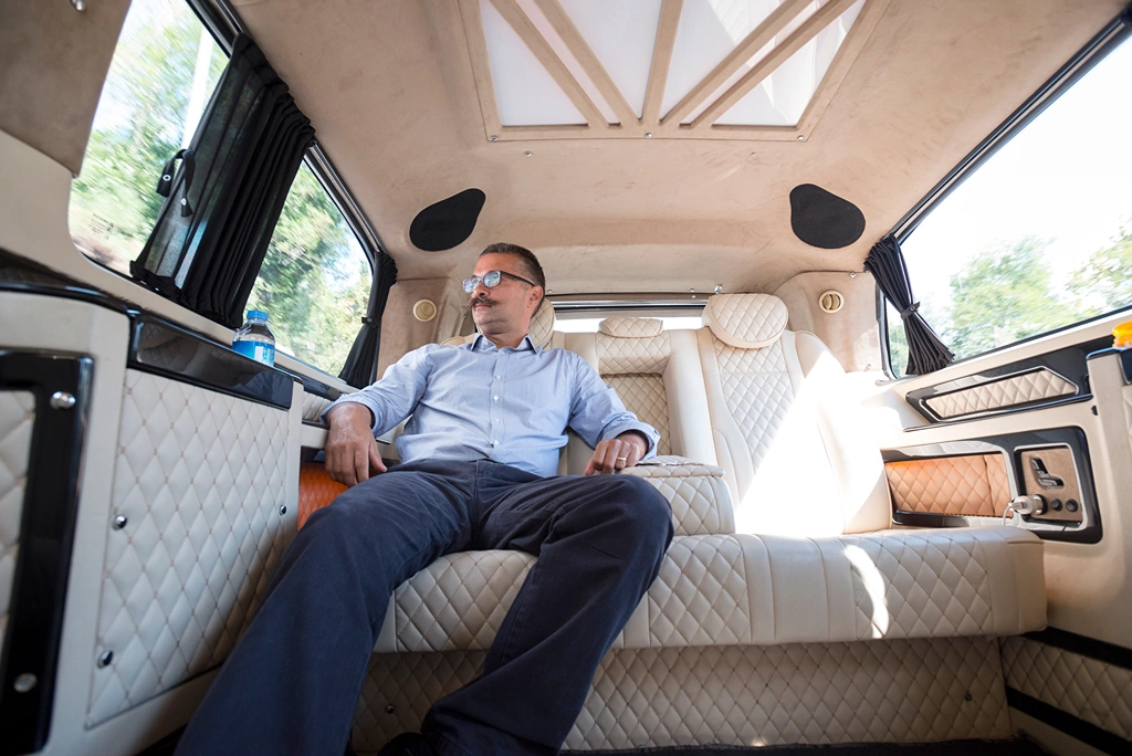 Businessman relaxing in back seat of moving car.