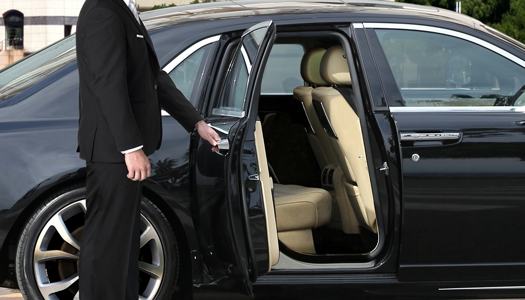 Chauffeur standing and opening car door