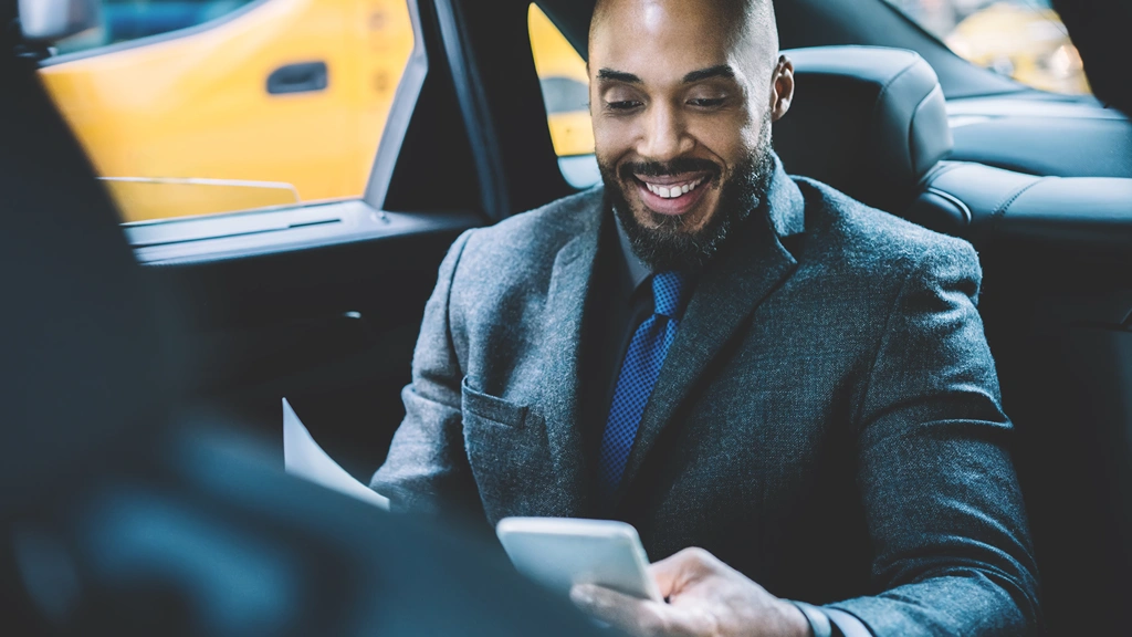 Cheerful male person dressed in elegant wear reading received email with good news about signing contract between two corporate enterprises, happy successful lawyer enjoying time for chatting in car