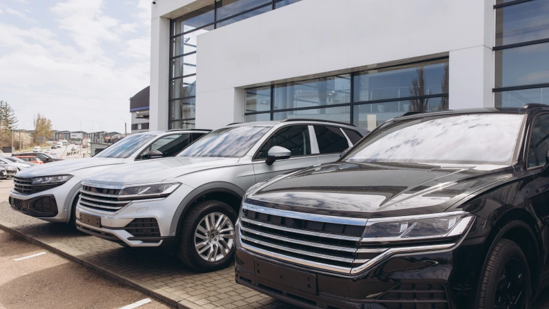 Shiny suv parked in front of a modern car dealership, representing the automotive industry and the concept of buying a new vehicle
