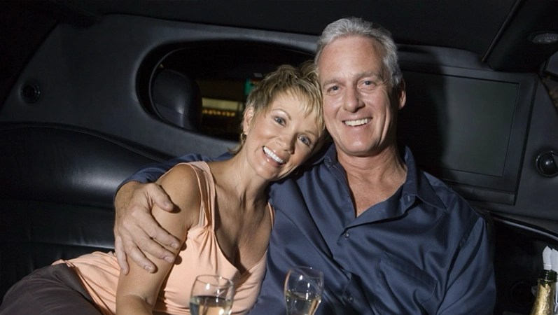 Senior couple toasting in a limousine