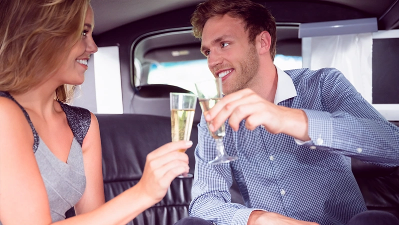 Happy couple drinking champagne in limousine on a Valentines Day night